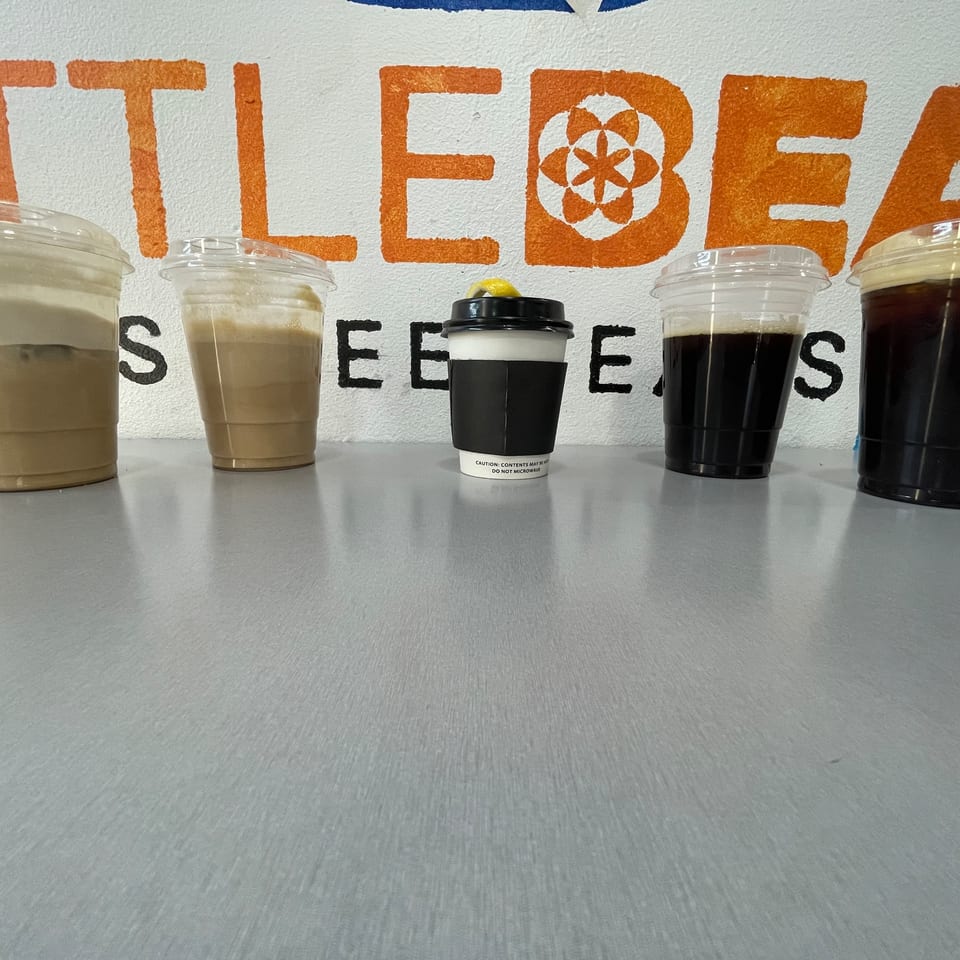Five Little Bear Street Eats beverages, including iced coffee and a hot drink, on a counter.
